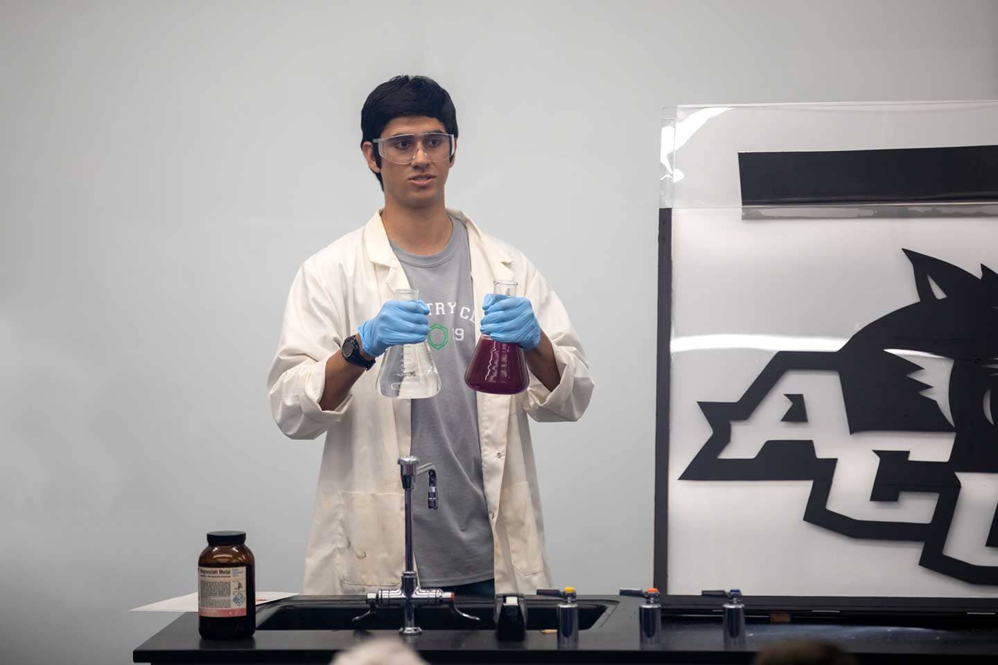 Student about to pour liquid from one flask to another