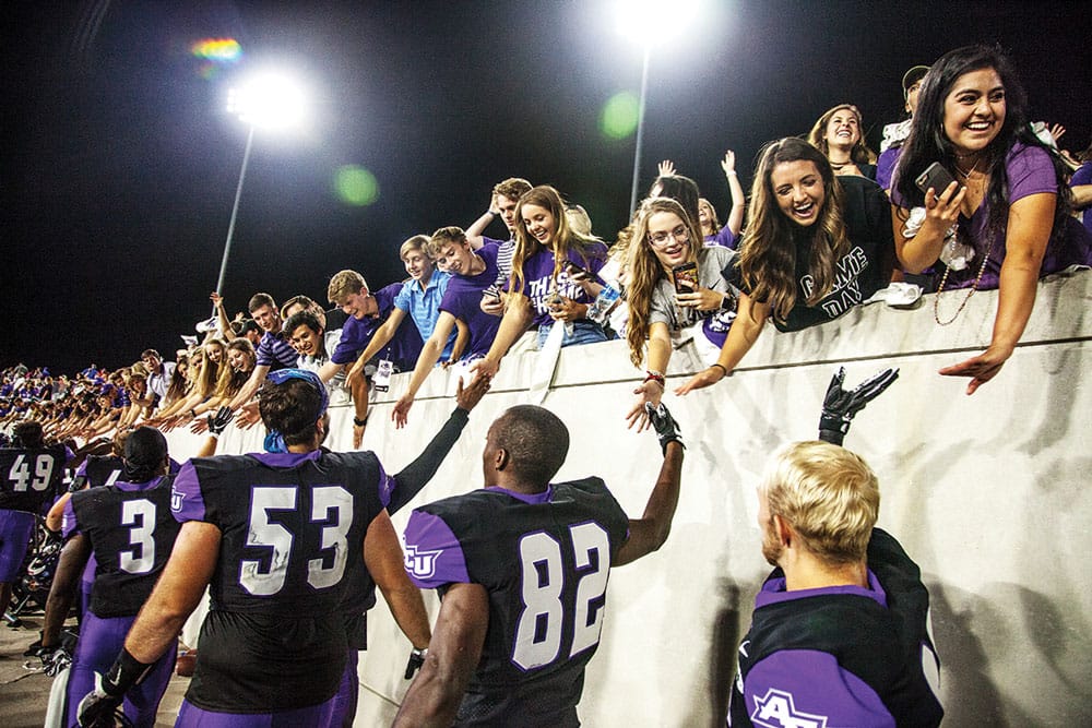 Football players high five fans - transfer to ACU