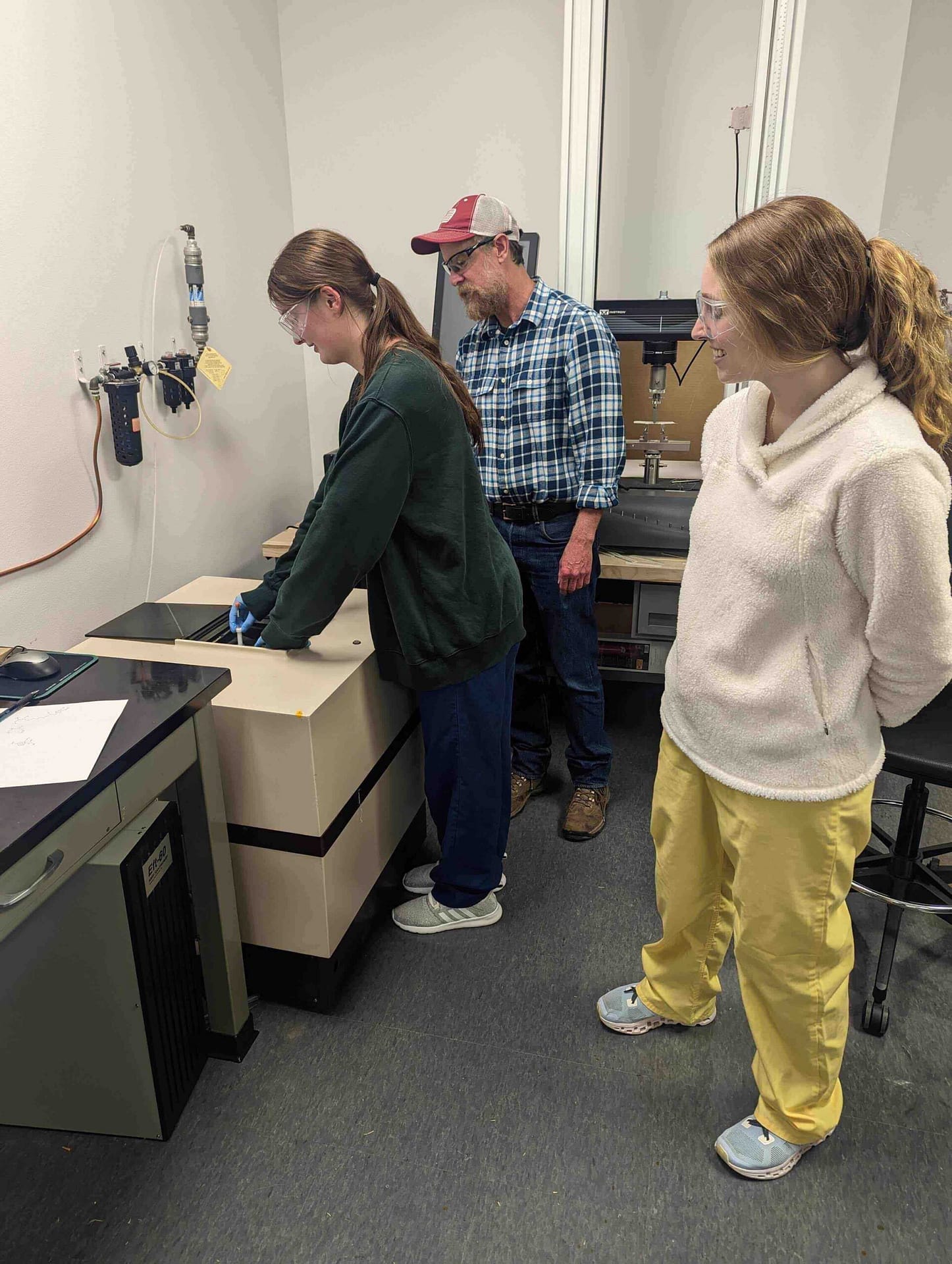 Students in the Department of Chemistry and Biochemistry working with an NMR to receive a closer look at molecular structures.